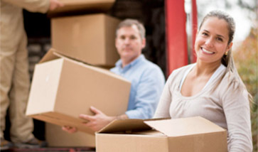 Man and woman loading moving boxes onto truck